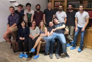 14 personnes sont debout ou assises sur un fauteuil